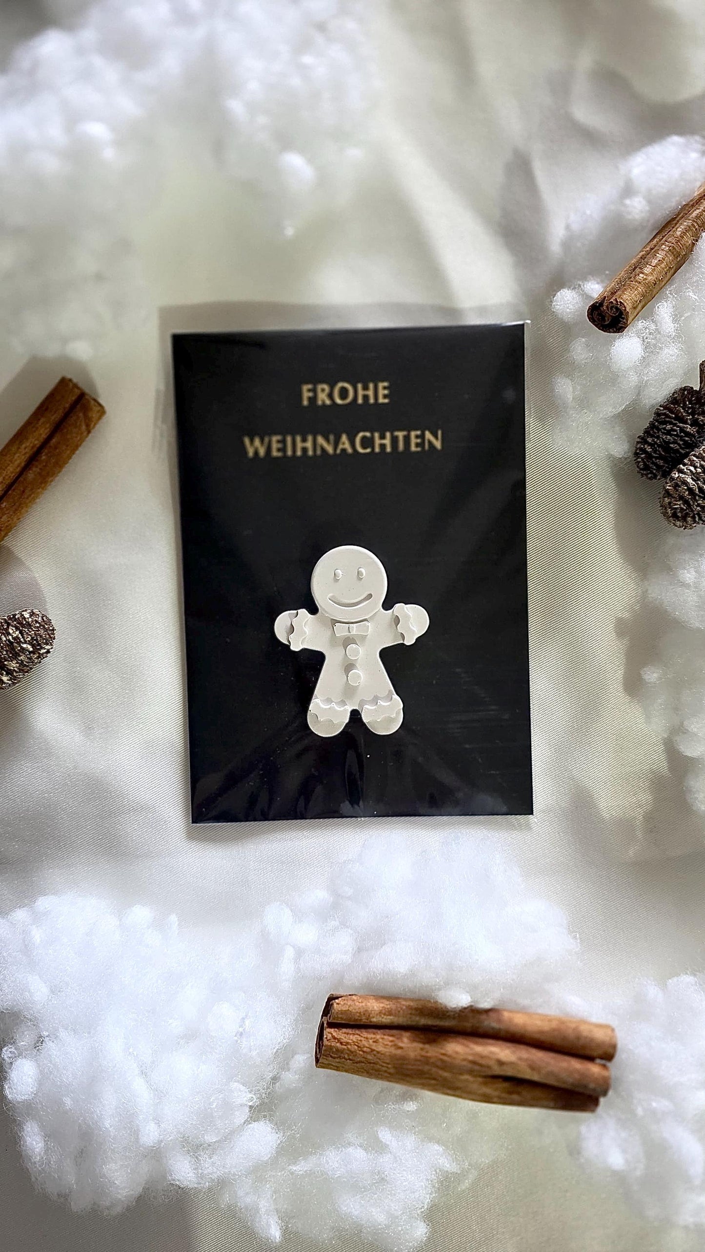 Detailaufnahme Figur Lebkuchenmann auf Weihnachtskarte mit „Frohe Weihnachten“-Prägung