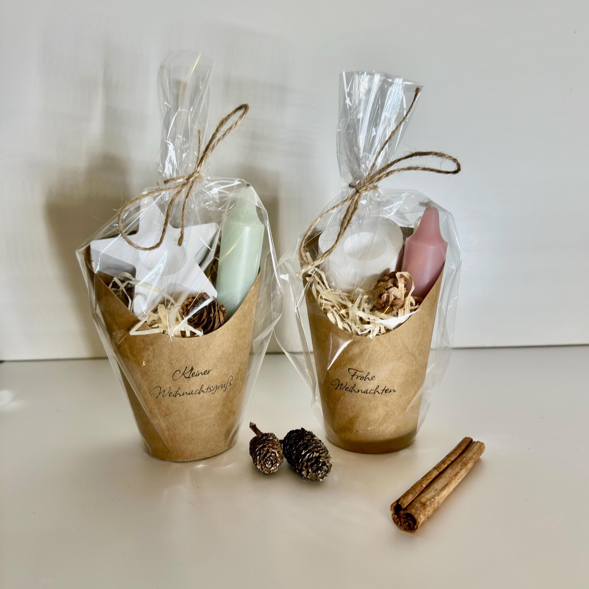 Weihnachtsset in Kraftpapiertüte mit Kerze, Kerzenhalter, Holzwolle und Tannenzapfen, liebevoll verpackt in Zellophan und Juteschnur.